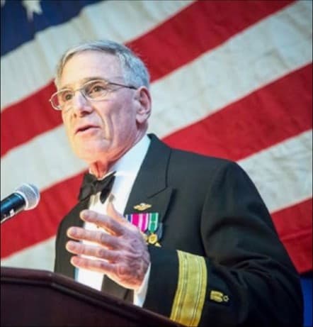 Rear Admiral Harold L. Robinson speaking at a podium